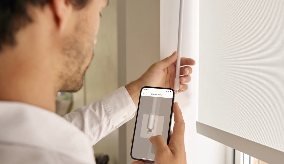 Person using a smartphone app to control roller shades