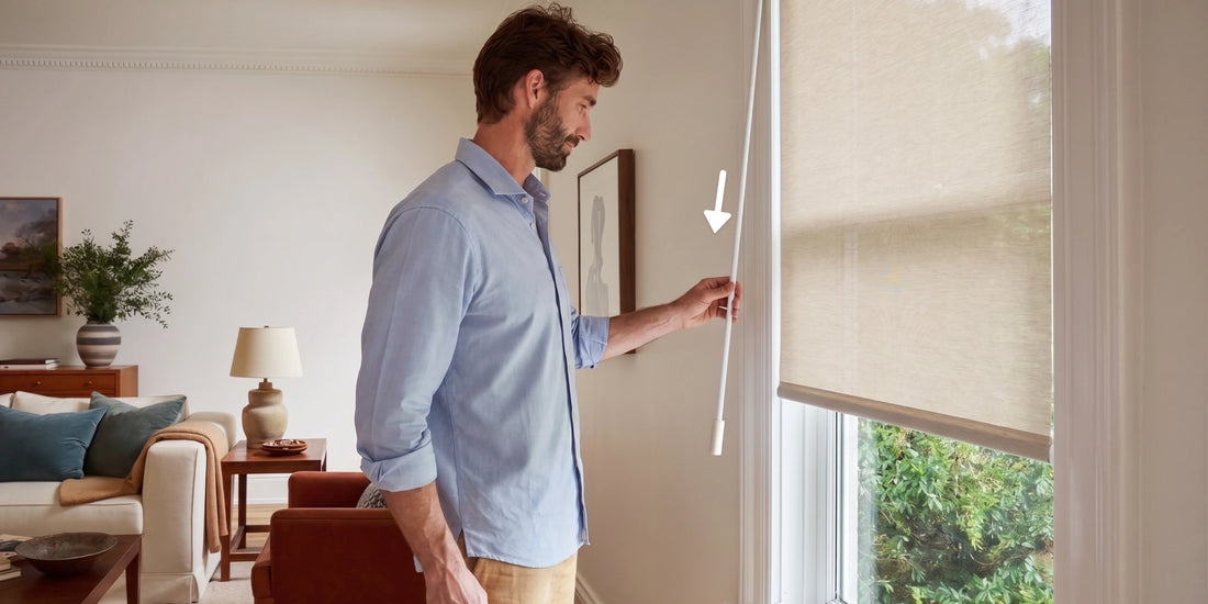 a man trying to pull down the wand to control the blinds
