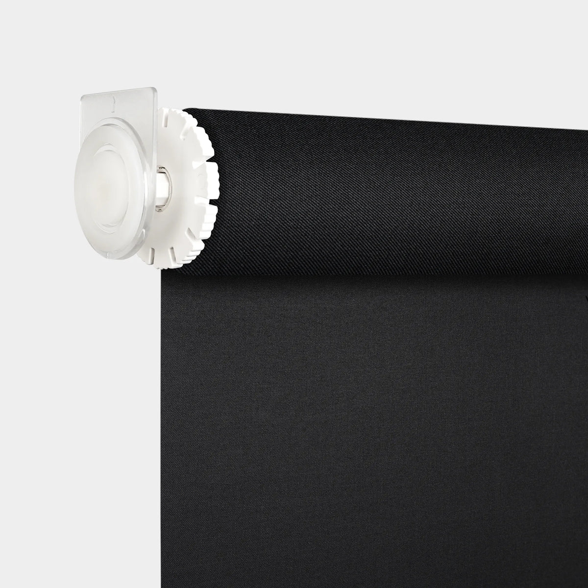 A close-up of a black fabric motorized no-drill roller shades