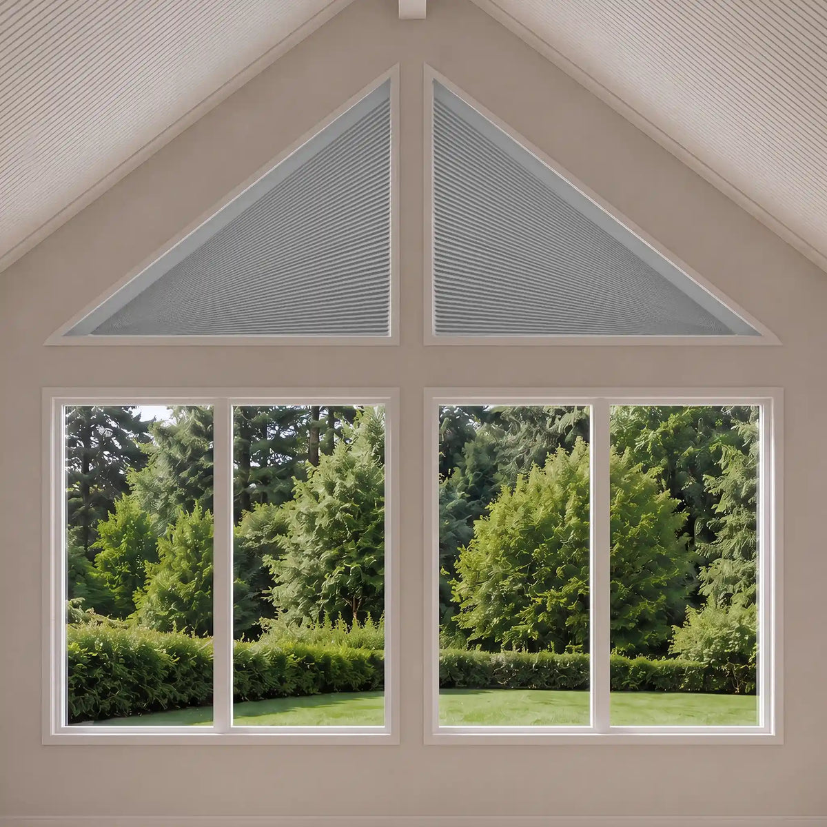 A set of white triangular shade installed in a gable window above two larger floor-to-ceiling windows, showing a green garden outside. The top two triangular sections have the shades drawn, while the lower windows show the outdoor scene.
