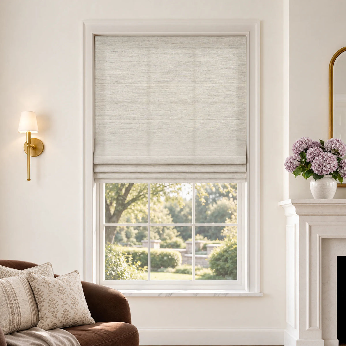 Plain fold Roman shades in Gilded Cream light-filtering fabric, partially raised on a window.