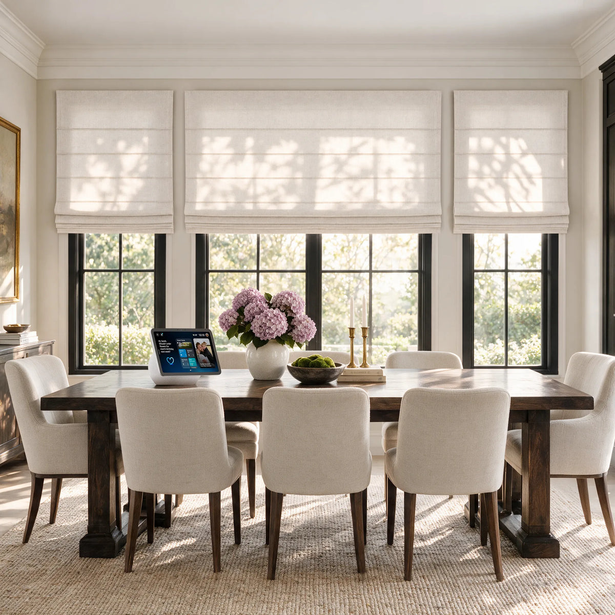 Plain fold Roman shades on dining room windows, with a smart display on the table.