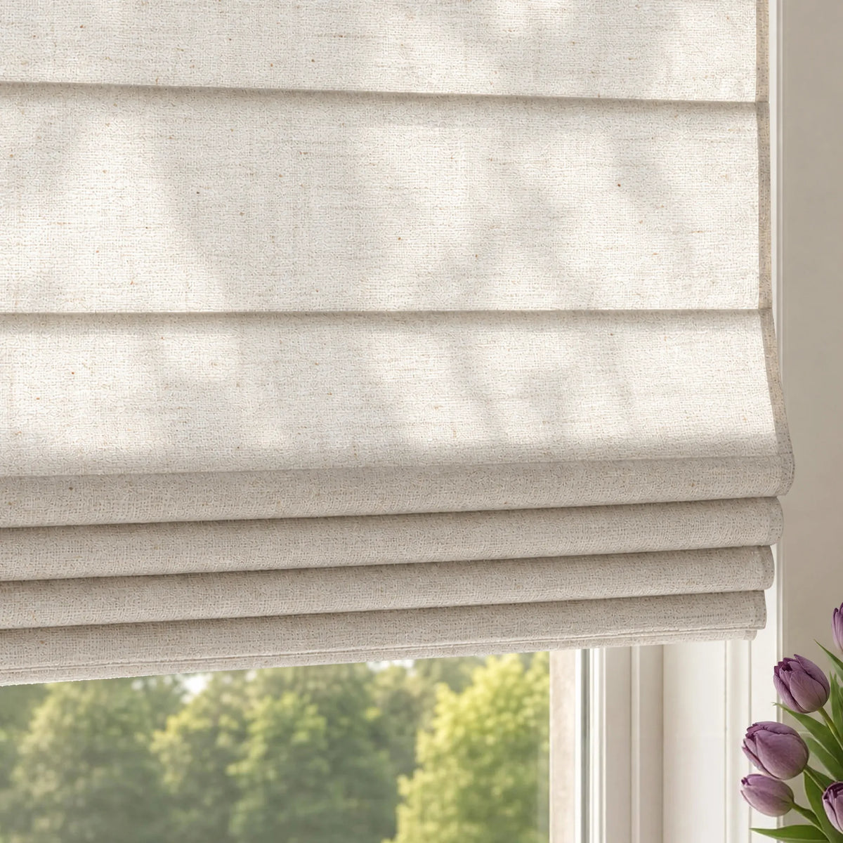Close-up of light-colored textured plain fold roman shades with horizontal fabric folds.