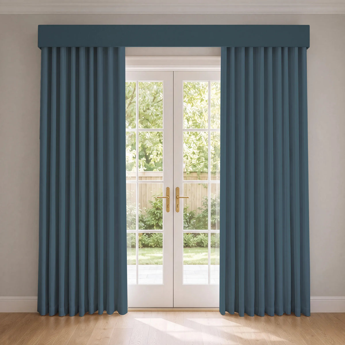 A pair of slate blue window curtains with a matching valance hanging on either side of white French doors in a bright room with light wood floors.