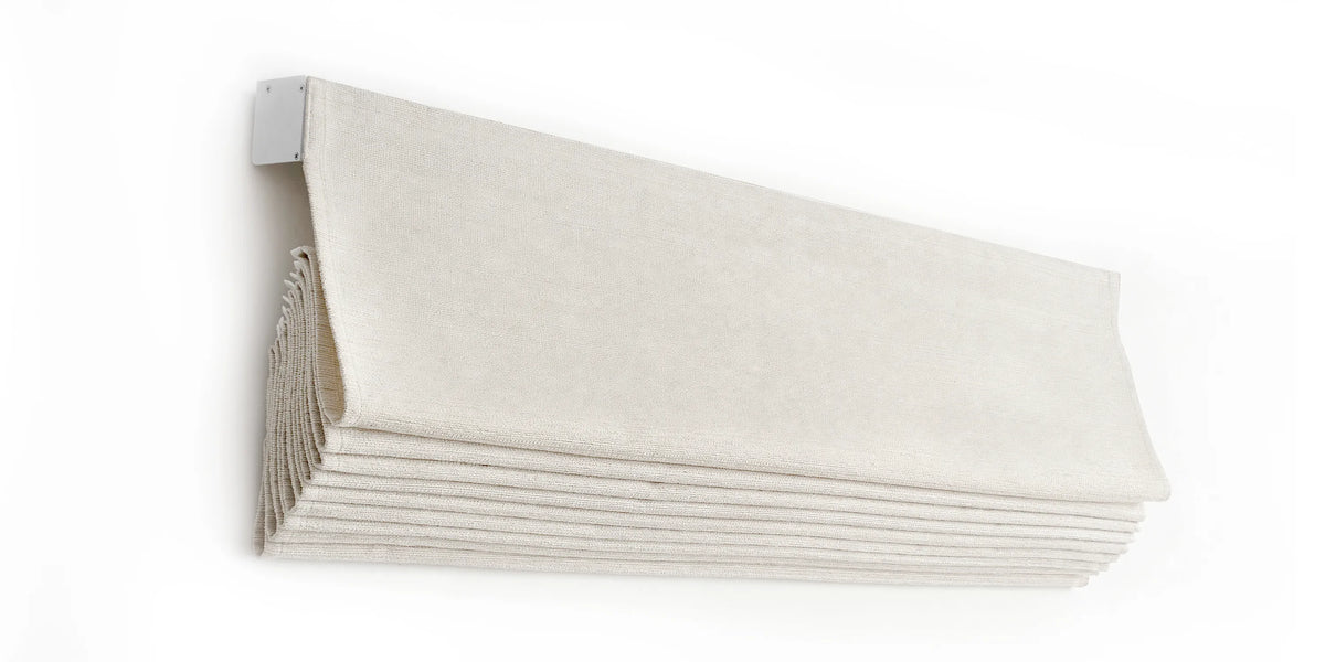 Angled view of a raised soft fold Roman shade showing stacked fabric loops and the headrail.