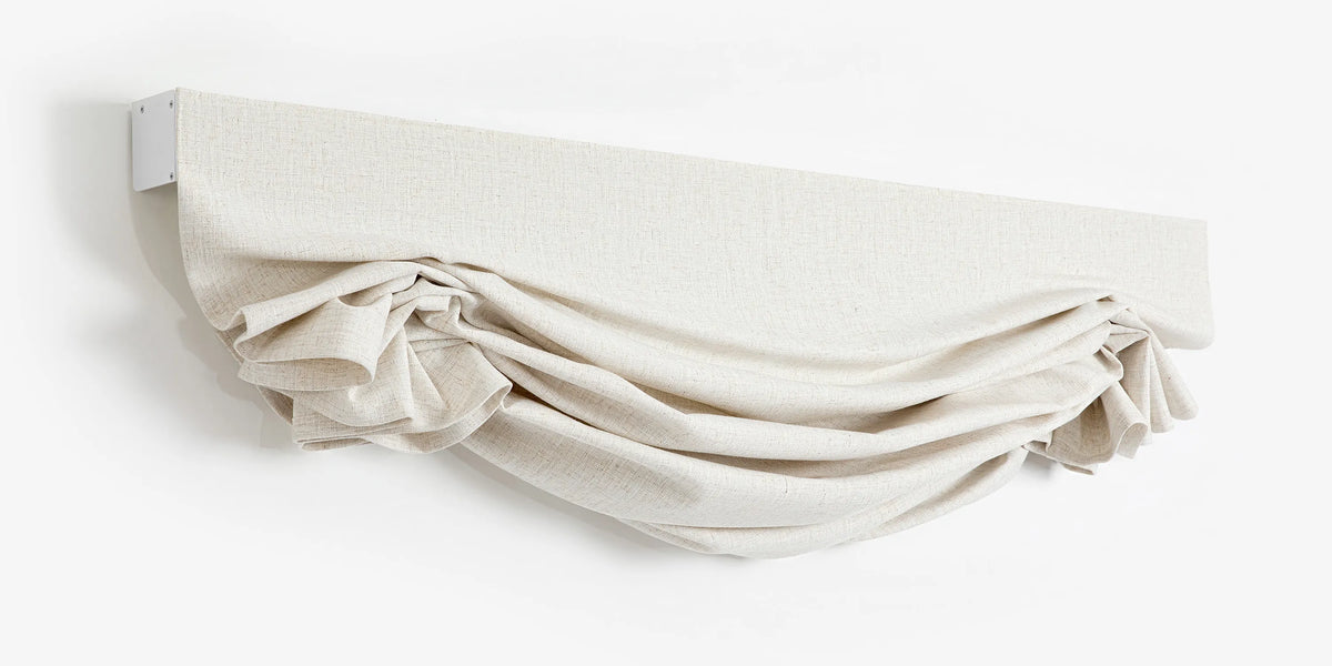 Raised swag Roman shade showing the headrail and gathered fabric folds against a white background.