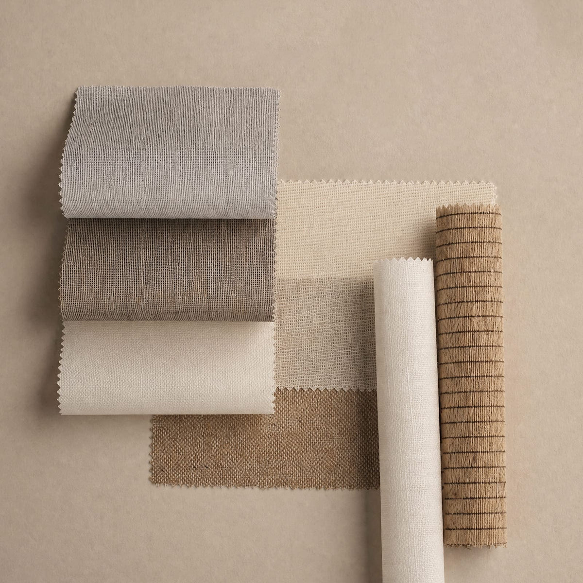 Collection of fabric swatches in neutral colors on a beige background