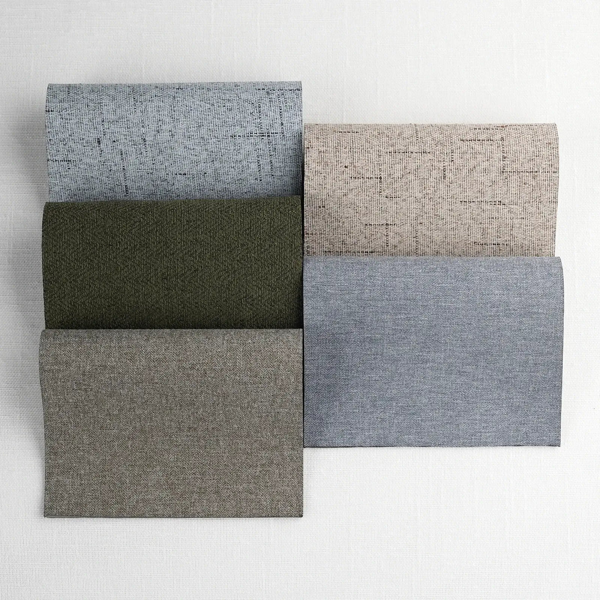 Collection of fabric swatches in various shades of gray and green on a white background