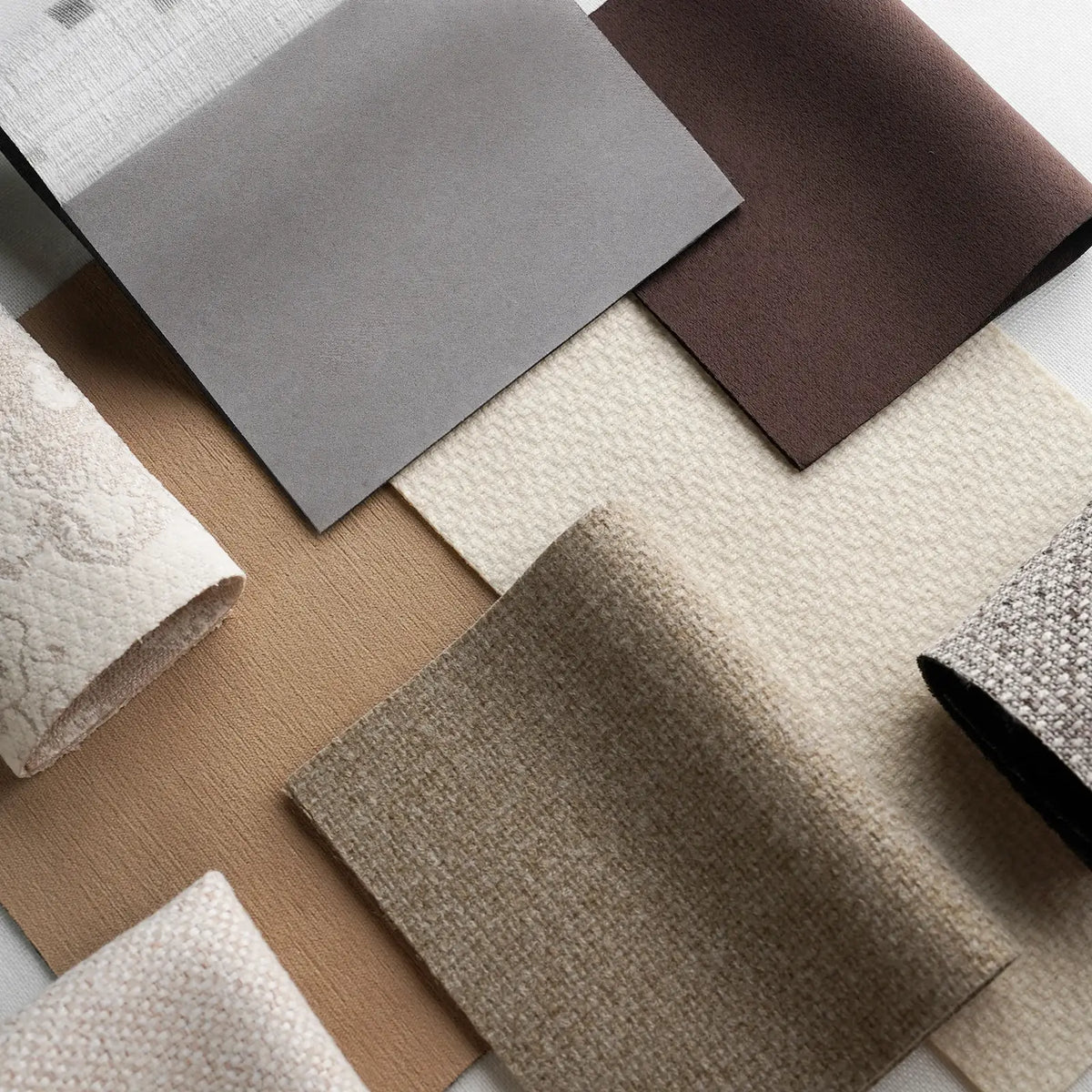 Collection of fabric swatches in various textures and colors on a neutral background