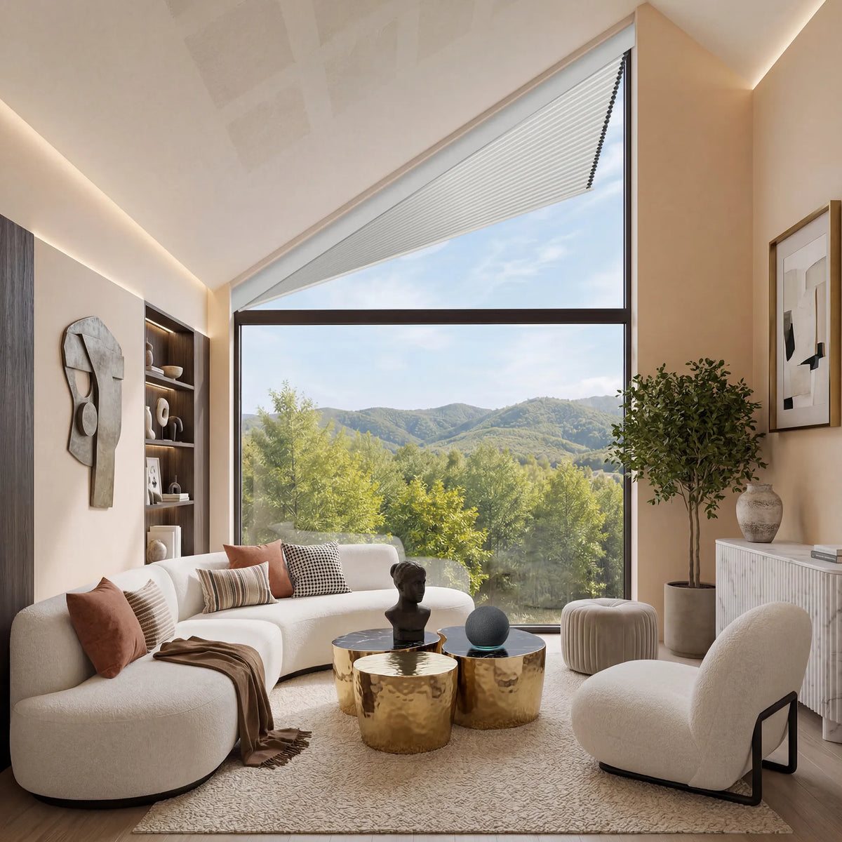 A modern living room with a curved white sofa, a matching accent chair, gold metallic coffee tables, and a large triangular window overlooking a forested mountain landscape.